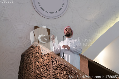 Image of Muslims young arabic Imam has a speech on friday afternoon prayer in mosque.