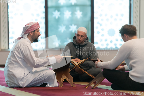 Image of muslim people in mosque reading quran together