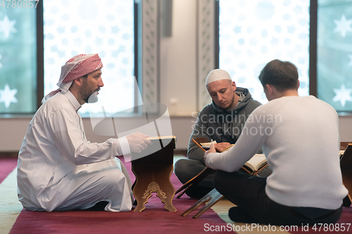 Image of muslim people in mosque reading quran together