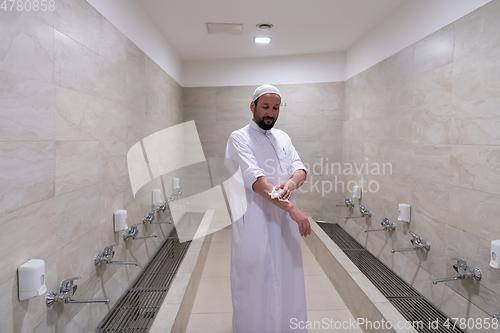 Image of a portrait of a man in abdesthana using a towel