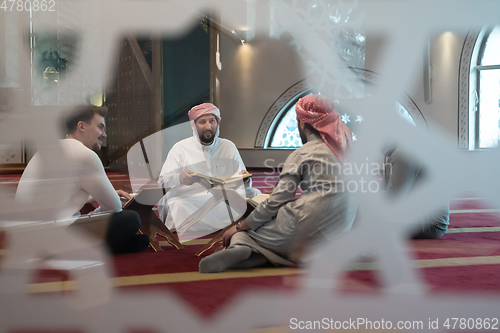 Image of muslim people in mosque reading quran together