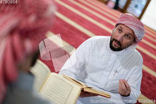 Image of two muslim people in mosque reading quran together concept of islamic education