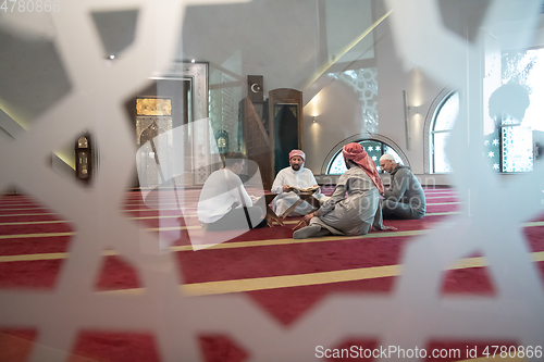 Image of muslim people in mosque reading quran together