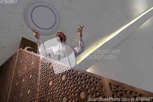 Image of Muslims young arabic Imam has a speech on friday afternoon prayer in mosque.