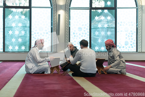 Image of muslim people in mosque reading quran together