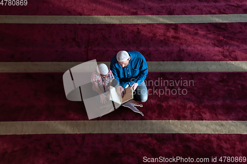 Image of father and son reading holly book quran together islamic education concept