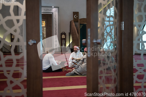 Image of muslim people in mosque reading quran together