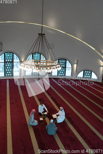 Image of muslim people in mosque reading quran together