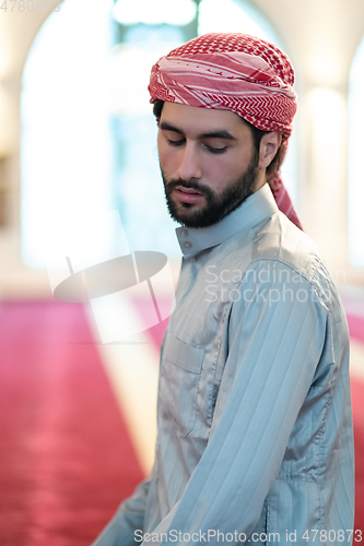 Image of a Muslim ends a prayer by turning his head to the side,.