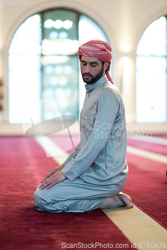 Image of a Muslim ends a prayer by turning his head to the side,.