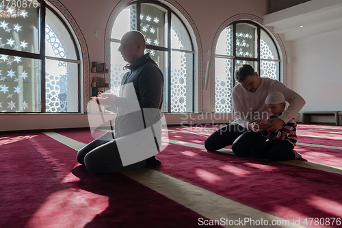 Image of muslim prayer father and son in mosque praying and 