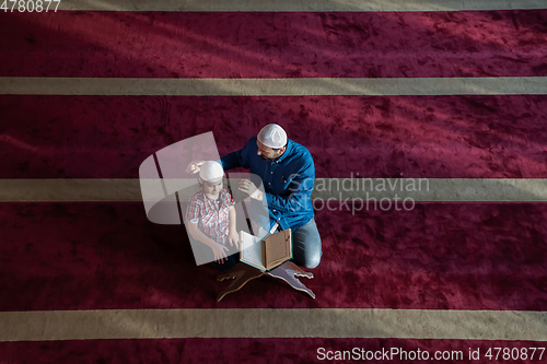 Image of father and son reading holly book quran together islamic education concept