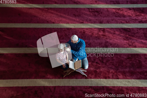 Image of father and son reading holly book quran together islamic education concept