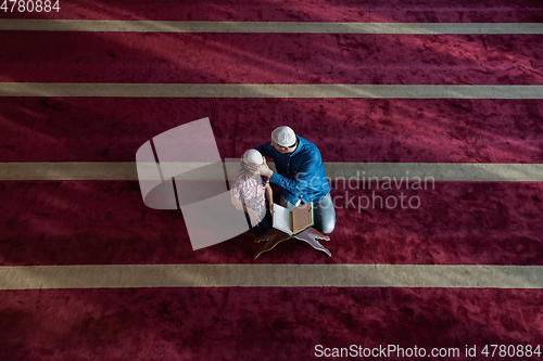 Image of father and son reading holly book quran together islamic education concept