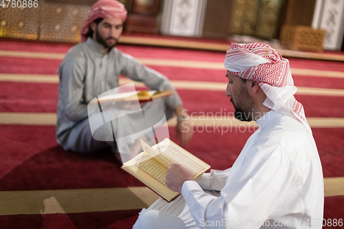 Image of two muslim people in mosque reading quran together concept of islamic education