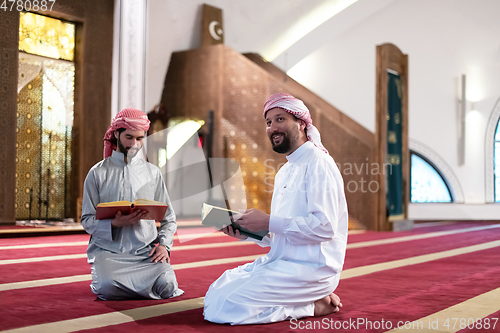Image of two muslim people in mosque reading quran together concept of islamic education