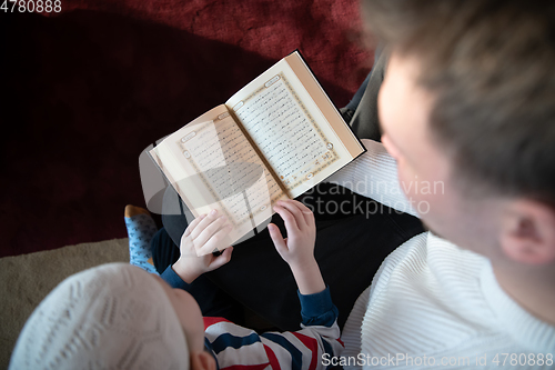 Image of  father and son in mosque praying and reading holly book quran together islamic education concept