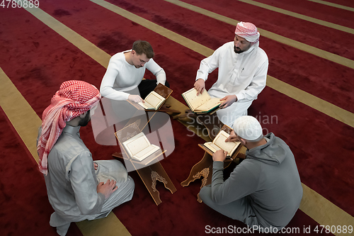 Image of muslim people in mosque reading quran together