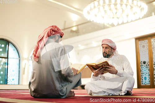 Image of two muslim people in mosque reading quran together concept of islamic education