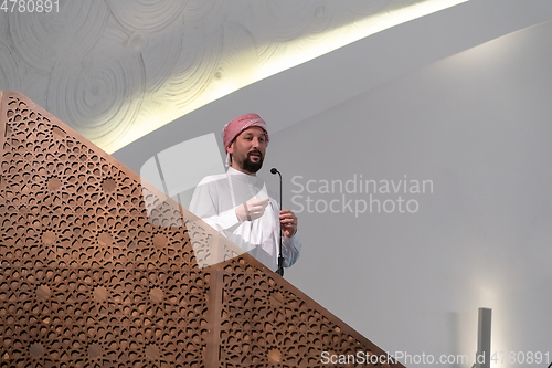 Image of Muslims young arabic Imam has a speech on friday afternoon prayer in mosque.