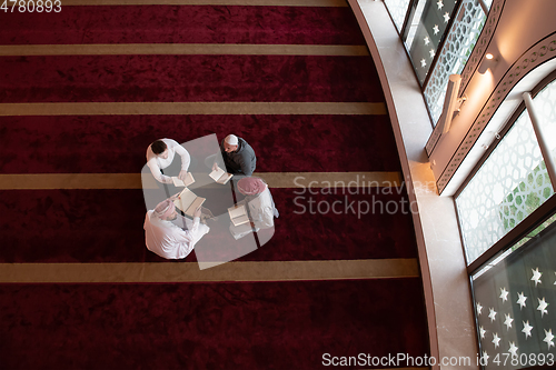 Image of muslim people in mosque reading quran together