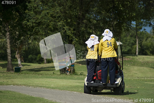 Image of Two caddies on a golf cart