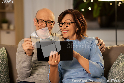 Image of happy senior couple with tablet pc and credit card