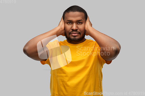 Image of stressed man closing his ears with hands