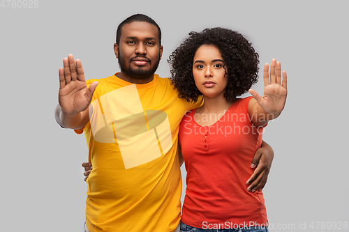 Image of african american couple showing stop gesture