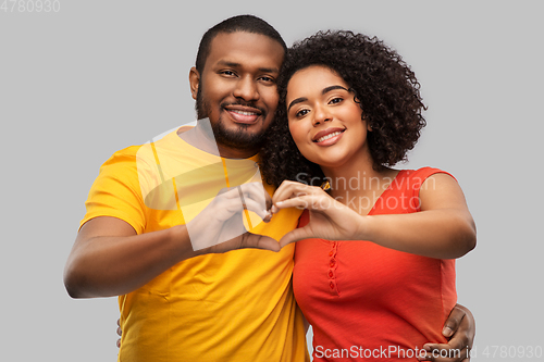 Image of happy african american couple making hand heart