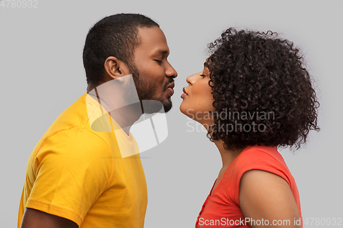 Image of happy african american couple reaching for kiss