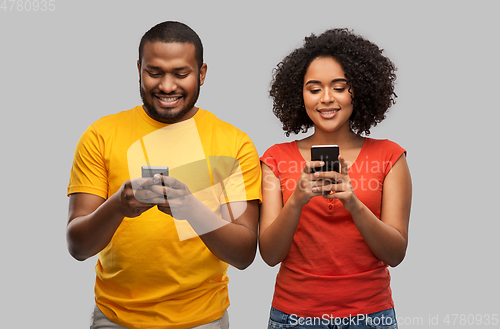 Image of happy african american couple with smartphones