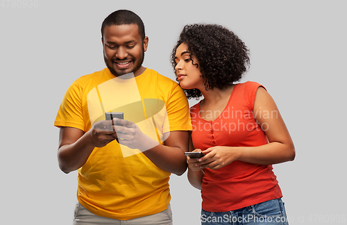 Image of happy african american couple with smartphones