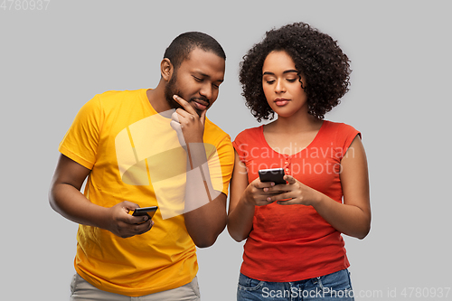 Image of happy african american couple with smartphones