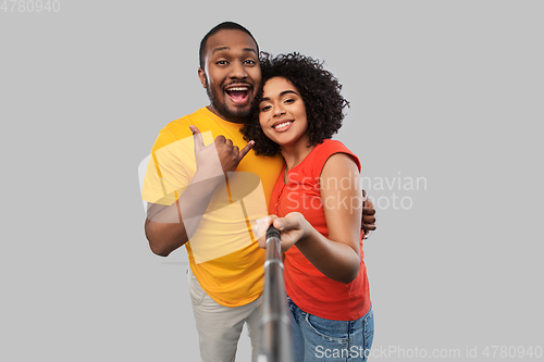 Image of african couple taking picture by selfie stick