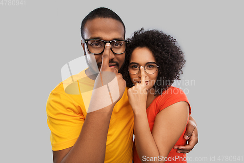Image of happy african american couple in glasses hugging