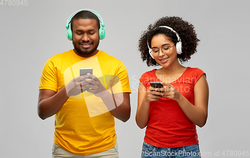 Image of african couple with headphones and smartphones