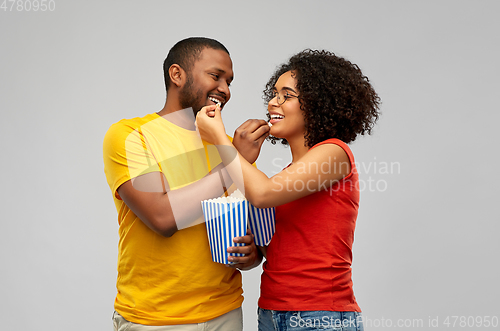 Image of happy african american couple eating popcorn