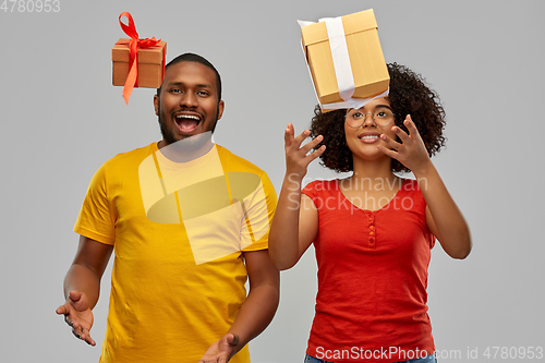 Image of happy african american couple throwing gift boxes