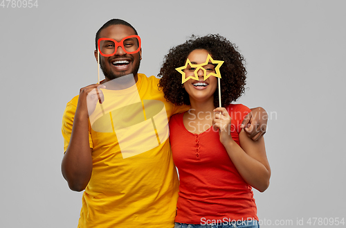 Image of happy african american couple with party props