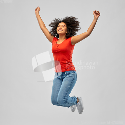 Image of smiling african american woman man jumping in air