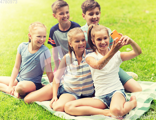 Image of happy kids or friends taking selfie in summer park