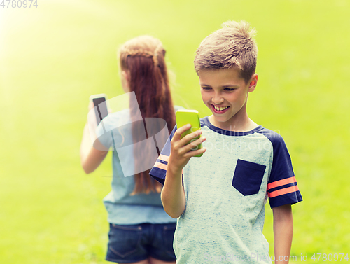 Image of kids with smartphones playing game in summer park