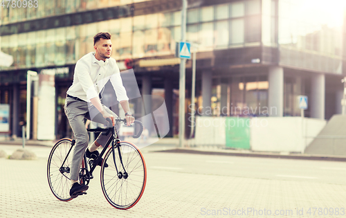 Image of man with headphones riding bicycle on city street