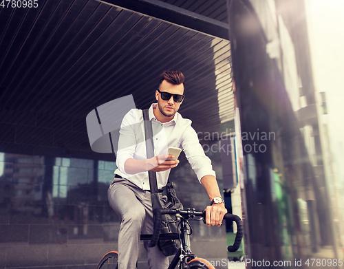 Image of man with bicycle and smartphone on city street