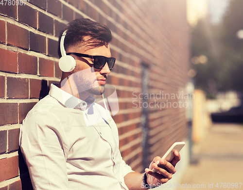 Image of man with headphones and smartphone listening music