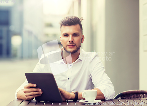 Image of man with tablet pc and coffee at city cafe