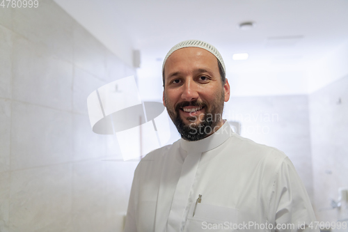 Image of a portrait of a man in abdesthana using a towel