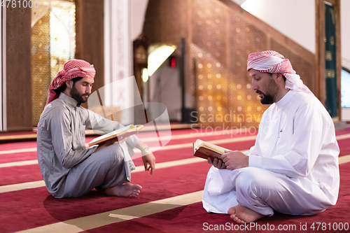 Image of two muslim people in mosque reading quran together concept of islamic education