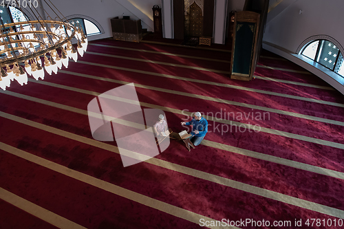 Image of father and son reading holly book quran together islamic education concept